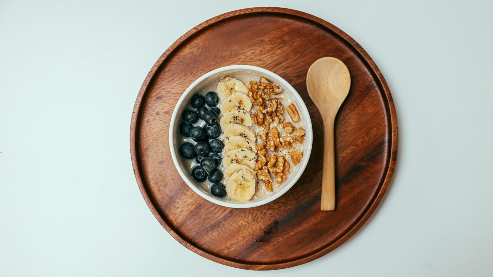 Yogur con avena y frutos secos servido en un plato con presentación sencilla.