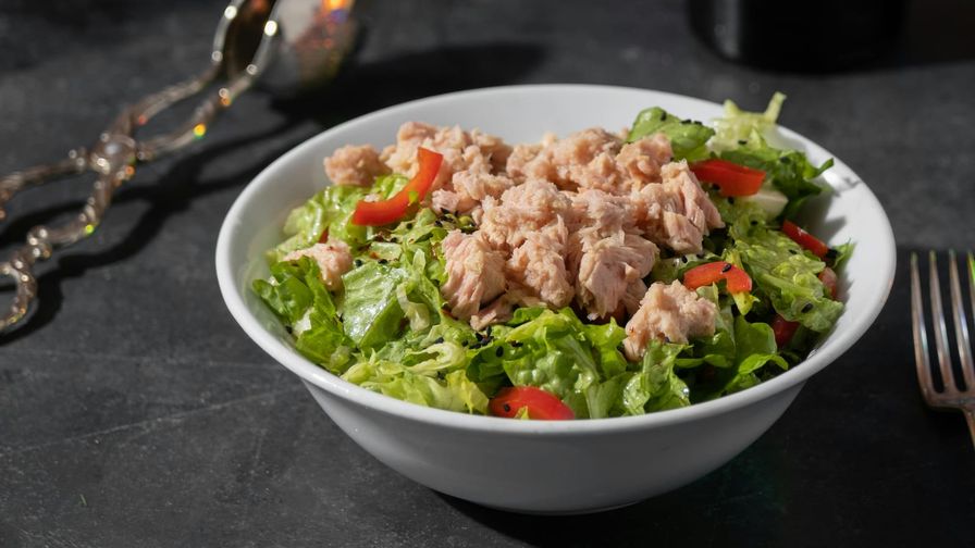 Ensalada de atún con hojas verdes y cítricos en un bol.