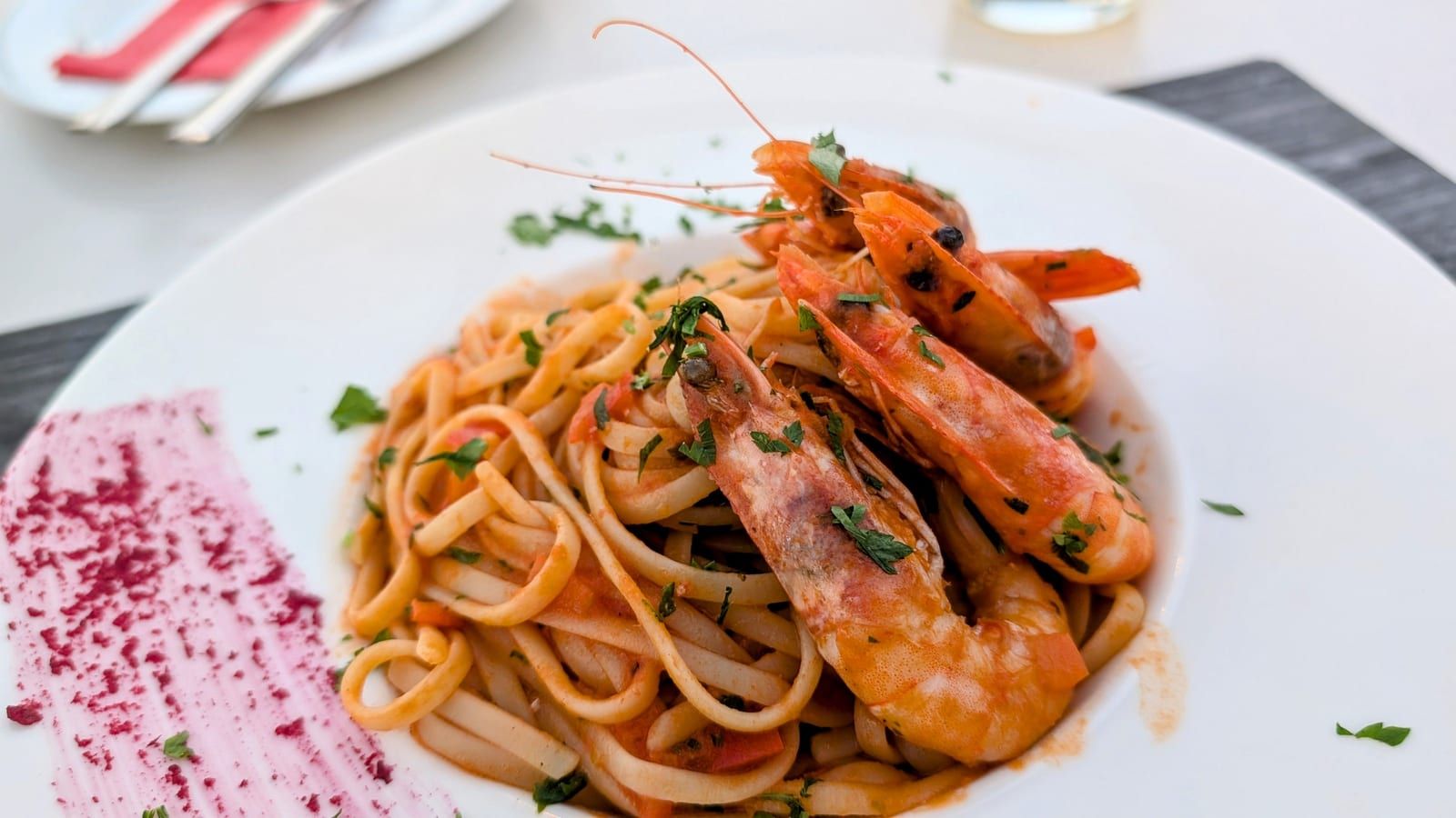 Pasta con salsa de mariscos servida en un plato blanco.