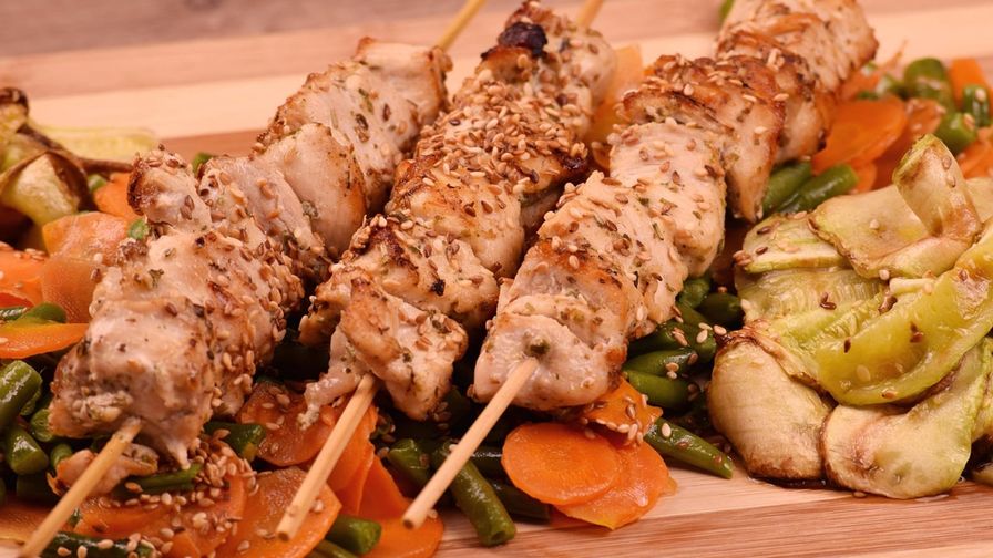 Brochetas de pollo y verduras servidas en un plato.