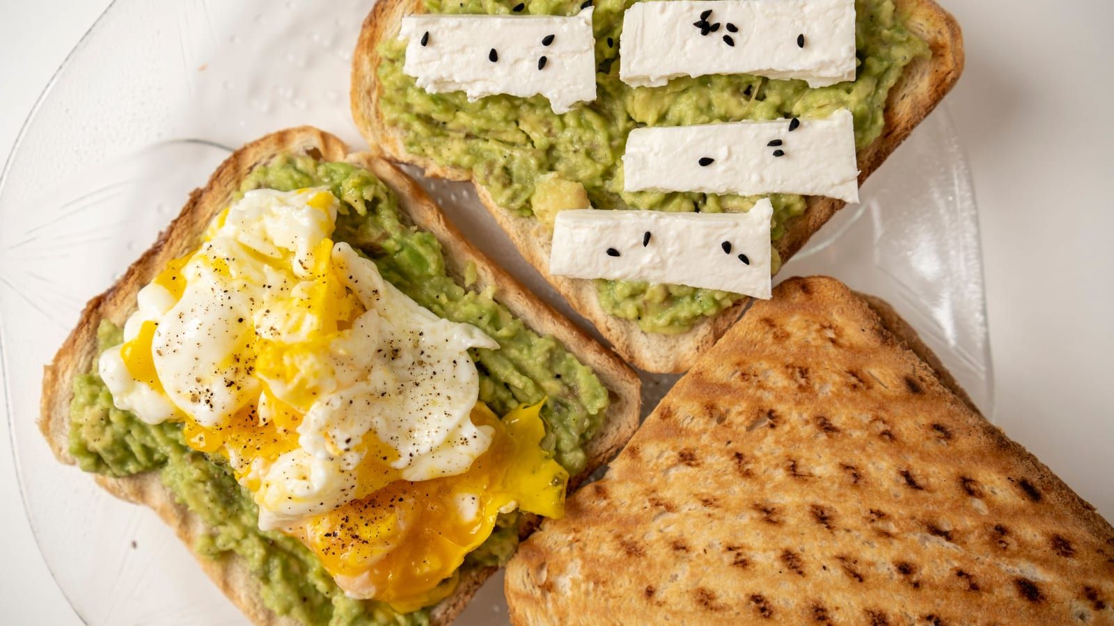Tostada de aguacate y huevo servido en un plato con presentación sencilla.