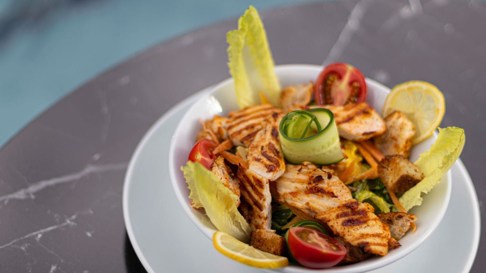 Ensalada verde con pollo servido en un plato con presentación sencilla.