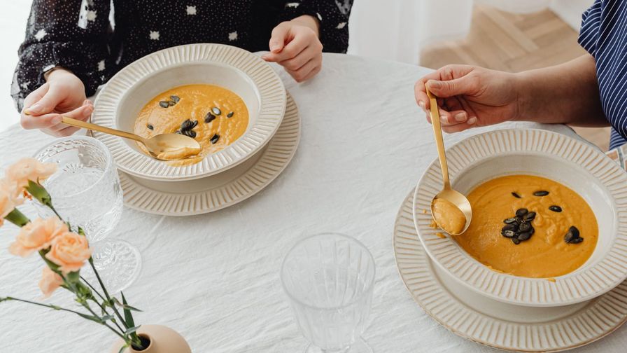 Crema de calabaza con lentejas servido en un plato con presentación sencilla.