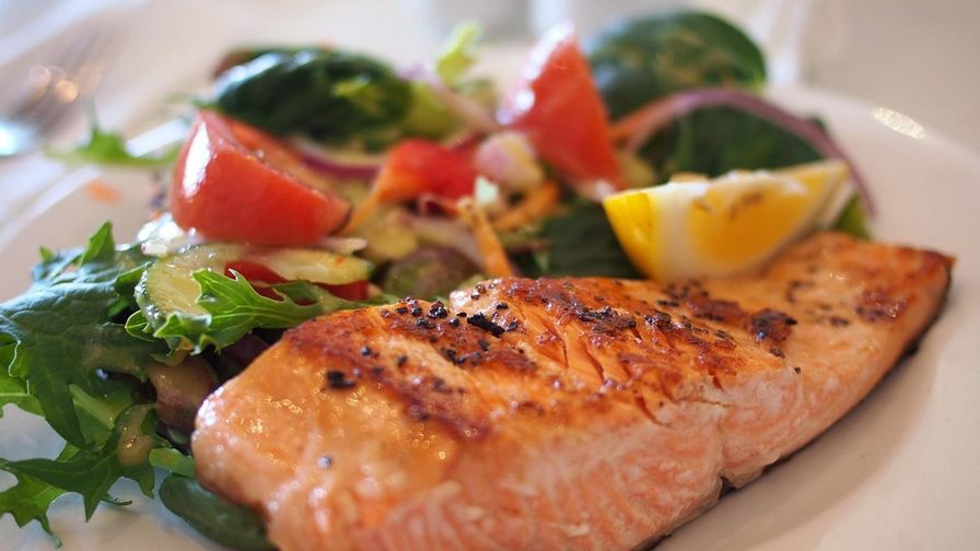 Salmón con mantequilla y limón servido en un plato con presentación sencilla.