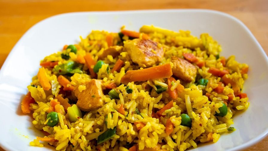 Pollo con arroz integral servido en un plato con presentación sencilla.