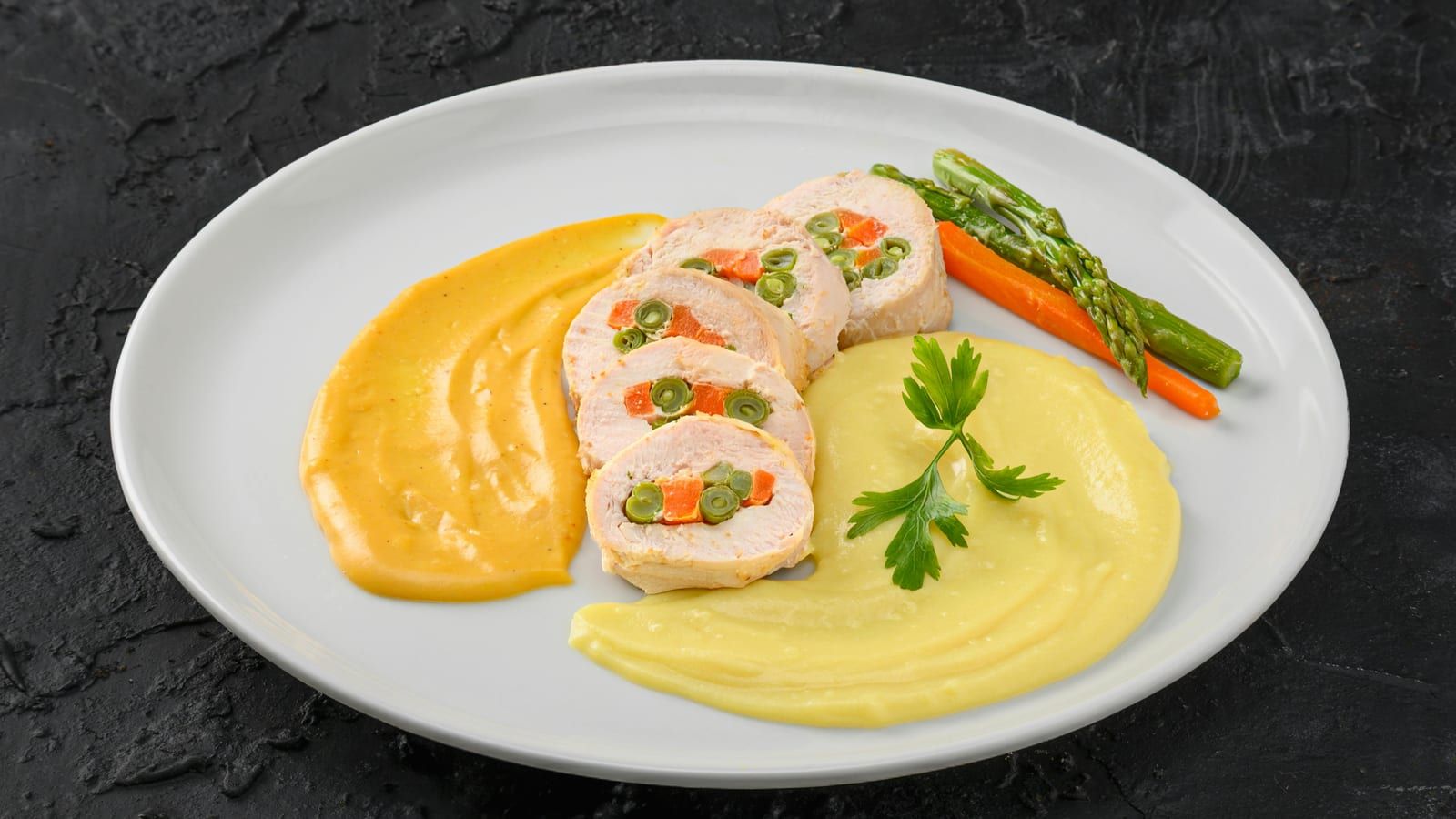 Puré servido junto a verduras en un plato.