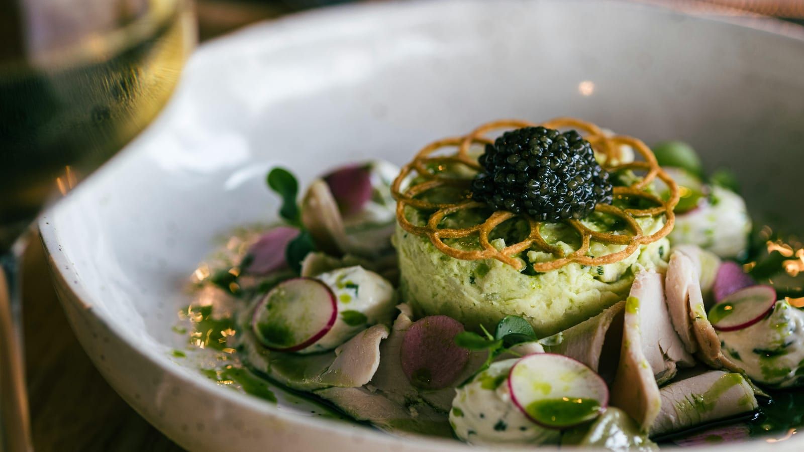 Ensalada verde con aguacate y pavo servido en un plato con presentación sencilla.